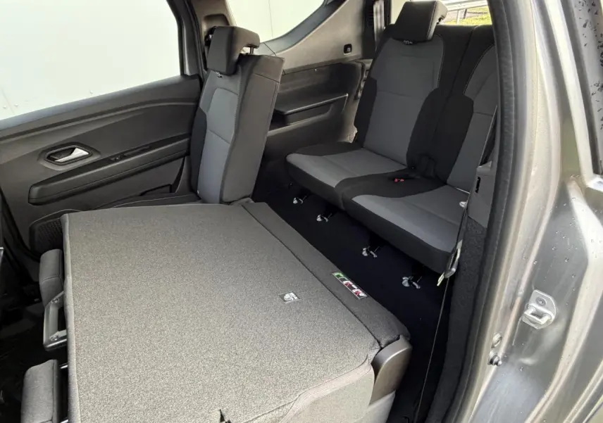 Vue intérieure côté droit du Dacia Jogger 2025 gris schiste, montrant les sièges arrière avec une partie rabattue.