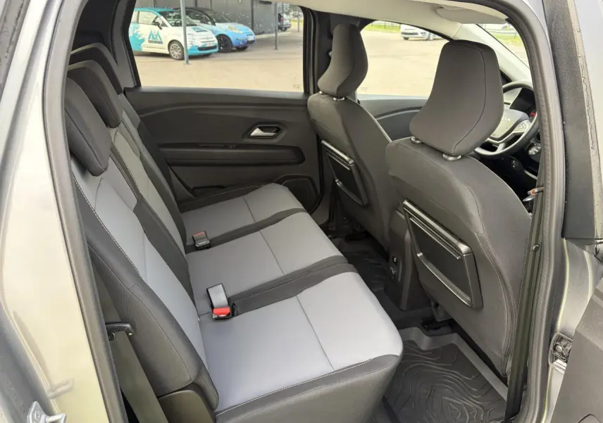 Vue intérieure côté gauche sur la banquette arrière grise et noire du Dacia Jogger 2025 avec rangements aux dossiers avant.