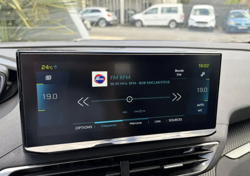 Écran tactile central du Peugeot 3008 Plug-in Hybrid affichant la radio FM RFM, vue intérieure avant.