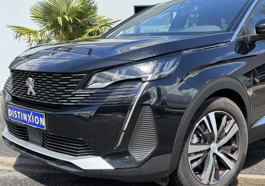 Vue 3/4 avant droite du Peugeot 3008 Plug-in Hybrid noir Perla avec calandre distinctive et jantes alliage bi-ton 18 pouces.