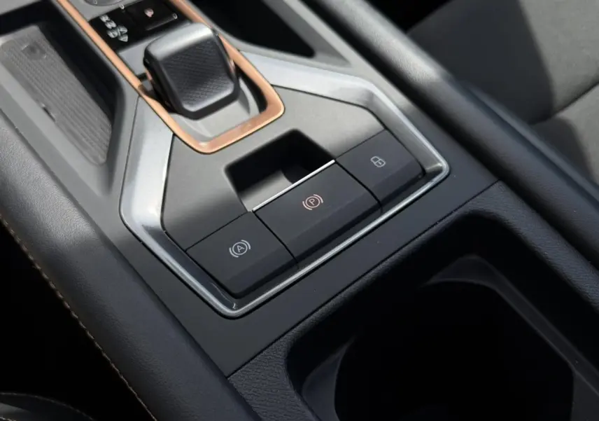 Gros plan sur la console centrale noire du CUPRA Formentor blanc avec levier de vitesse et boutons de frein à main électronique.