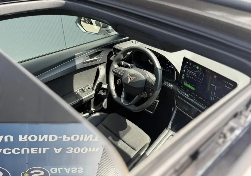 Vue intérieure côté conducteur du CUPRA Formentor 2025, volant cuir noir avec logo, écran tactile et tableau de bord digital.