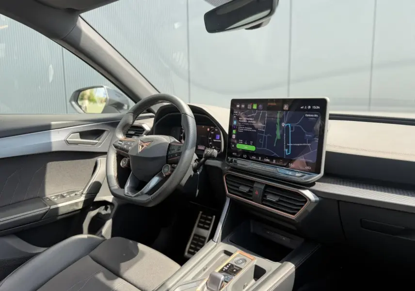 Vue intérieure côté conducteur du CUPRA Formentor 2025 avec tableau de bord noir et écran tactile central lumineux.
