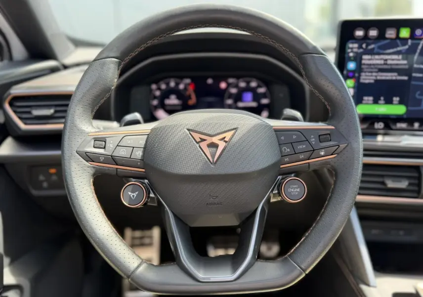 Vue rapprochée du volant cuir perforé noir avec logo CUPRA cuivré et commandes multifonctions du Formentor 2025.