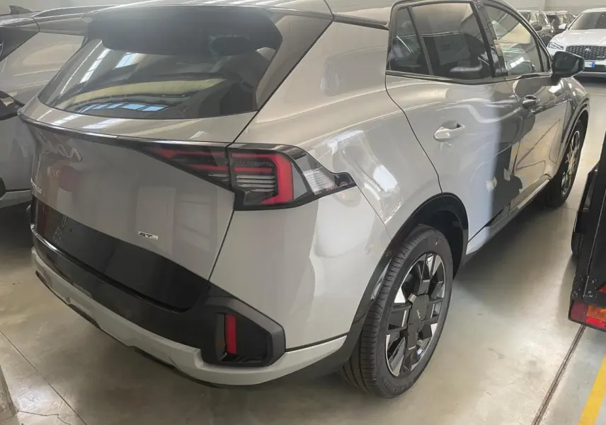 Vue 3/4 arrière droite du KIA SPORTAGE 2026 gris lunaire hybride GT-Line avec jantes au design distinctif.
