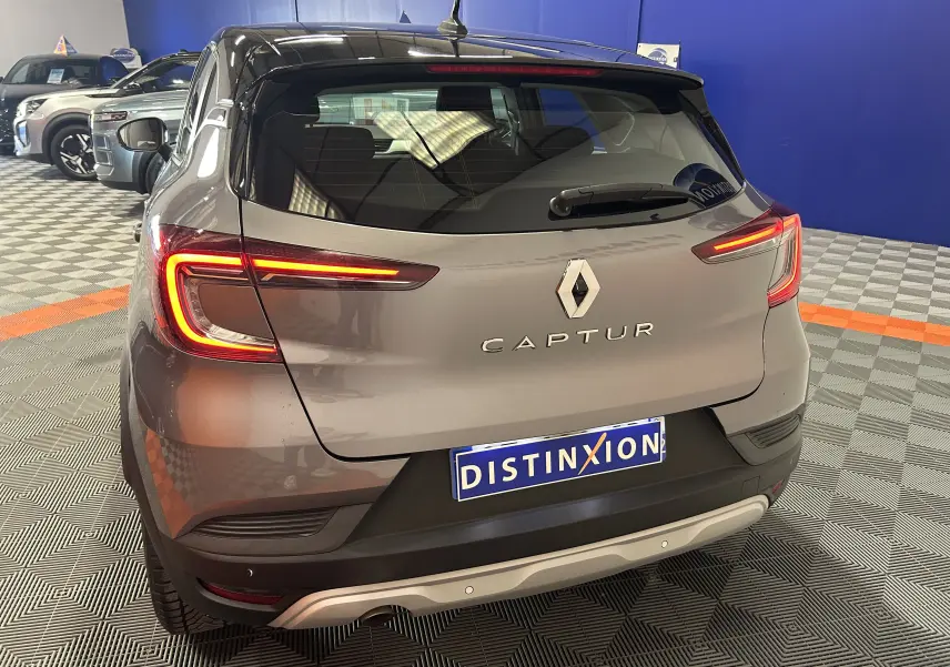 Vue arrière d'un Renault Captur gris 2022 avec feux LED allumés dans un showroom.