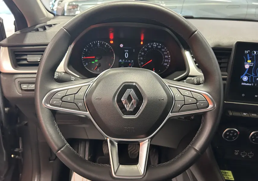 Vue centrée sur le volant noir du Renault Captur 2022 avec tableau de bord et écran GPS visible à droite.