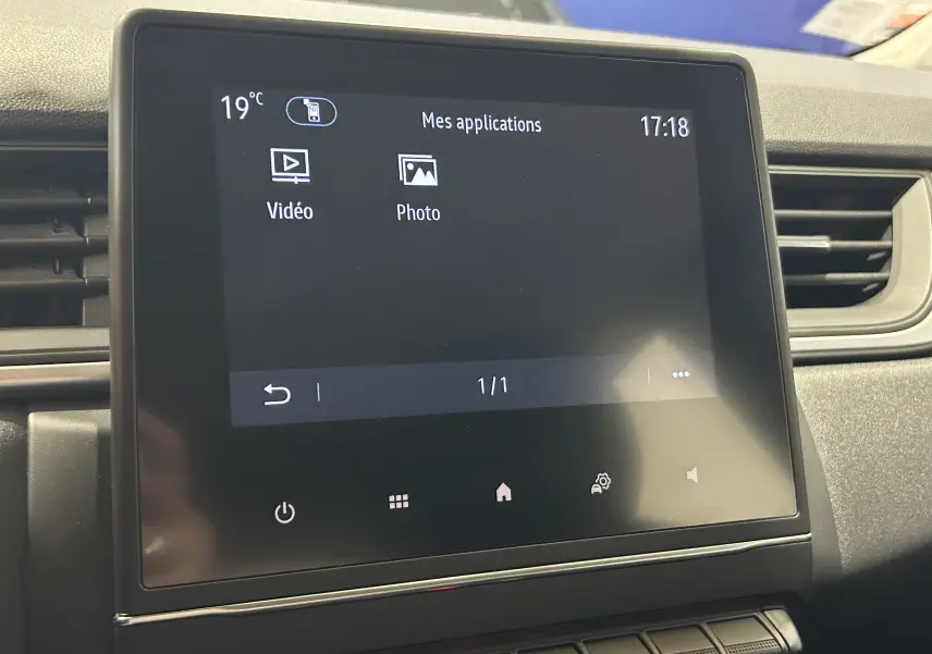 Écran tactile central du tableau de bord du Renault Captur gris, affichant les applications vidéo et photo.