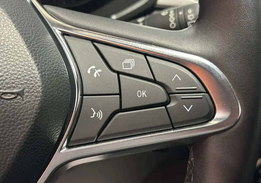 Gros plan sur les commandes multifonctions noires du volant côté droit du Renault Captur gris 2022.