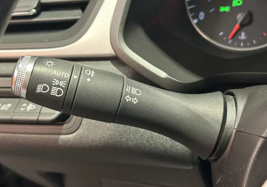 Gros plan sur la commande des feux et clignotants noire dans l’habitacle du Renault Captur gris 2022.