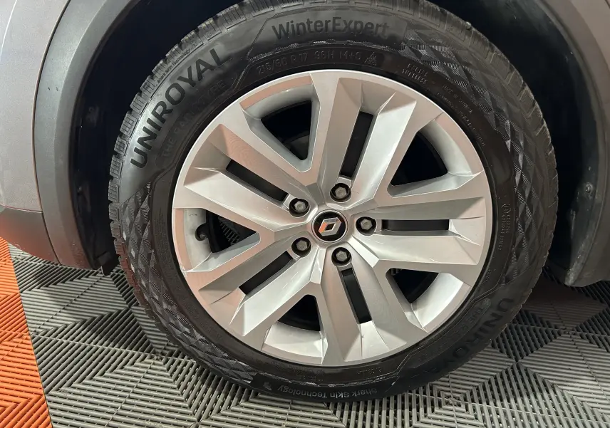 Gros plan sur la roue avant droite grise du Renault Captur II TCE 90 avec jante alliage et pneu hiver Uniroyal.