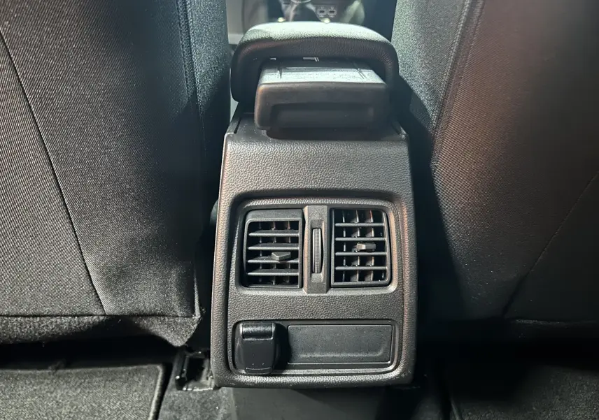 Vue rapprochée des aérateurs arrière et prise 12V entre les sièges avant d’un Renault Captur gris 2022.