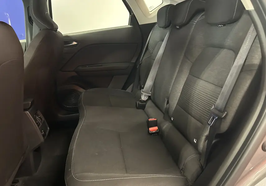 Vue intérieure côté droit des sièges arrière en tissu noir du Renault Captur gris, avec ceintures de sécurité visibles.