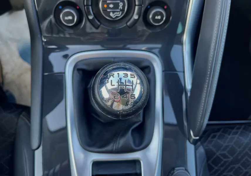 Le levier de vitesses manuel en chrome de la Peugeot 3008 gris clair, vue rapprochée du tableau de bord central.