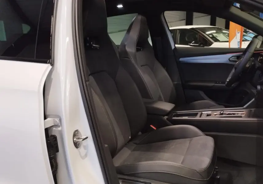 Vue intérieure côté conducteur du CUPRA Formentor blanc Nevada, sièges baquets suédine noire avec surpiqûres cuivrées.