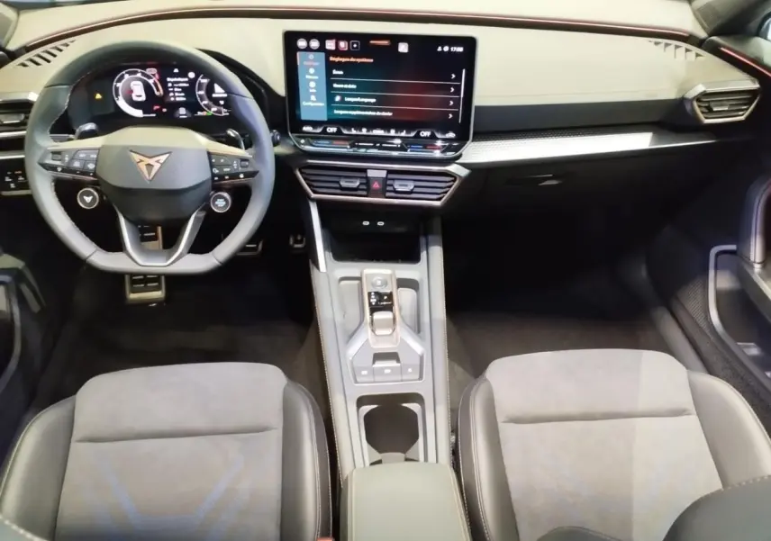 Intérieur CUPRA Formentor vue avant, sièges suédine noir et bleu, tableau de bord noir avec écran tactile central.