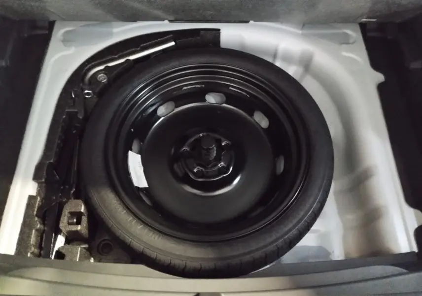 Vue rapprochée de la roue de secours compacte noire dans le coffre du CUPRA Formentor Nevada White 2026.