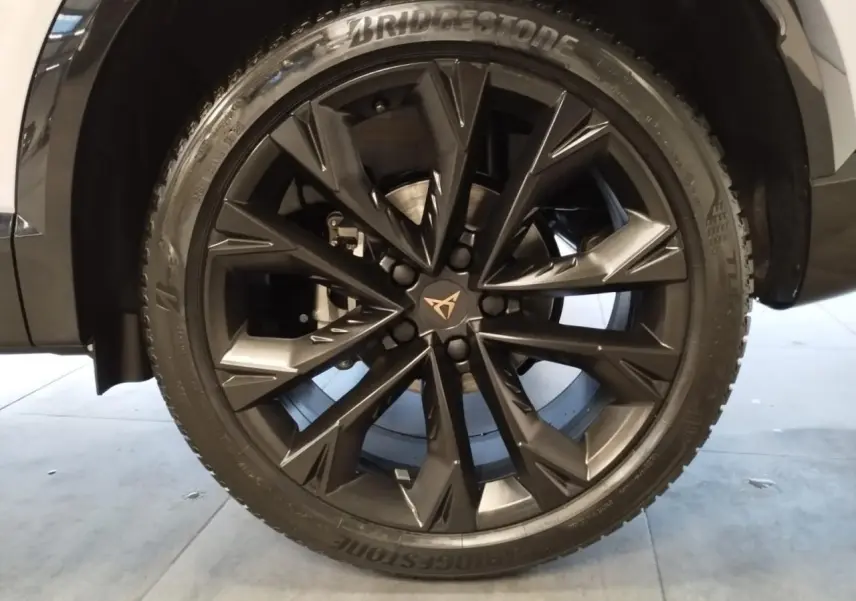 Gros plan sur la jante alliage 19'' Sandstorm noire du CUPRA Formentor Nevada White, avec logo Cupra central.