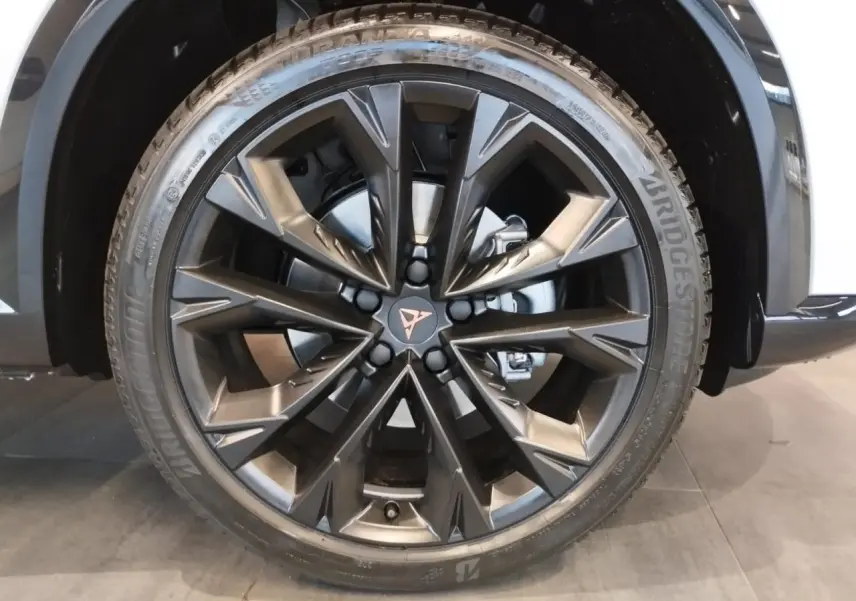 Gros plan sur la jante alliage 19'' Sandstorm noire du CUPRA Formentor Nevada White, avec logo Cupra central cuivré.