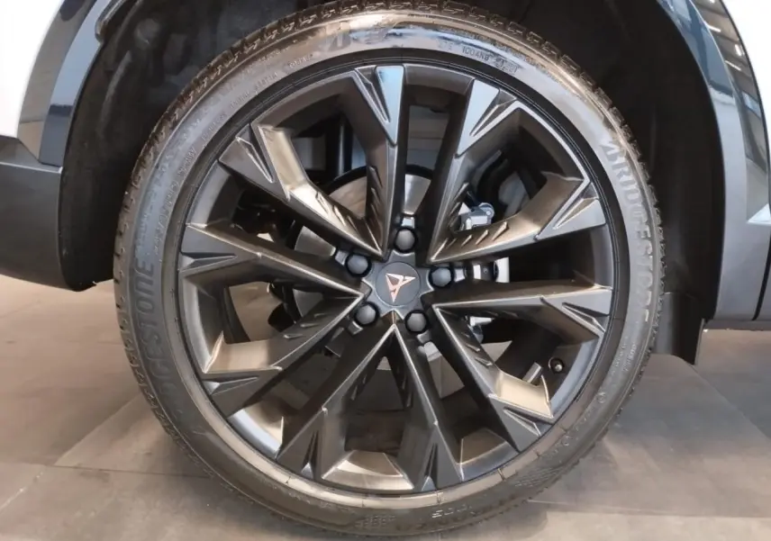 Gros plan sur la jante alliage noire 19'' Sandstorm du CUPRA Formentor Nevada White, avec logo Cupra central cuivré.