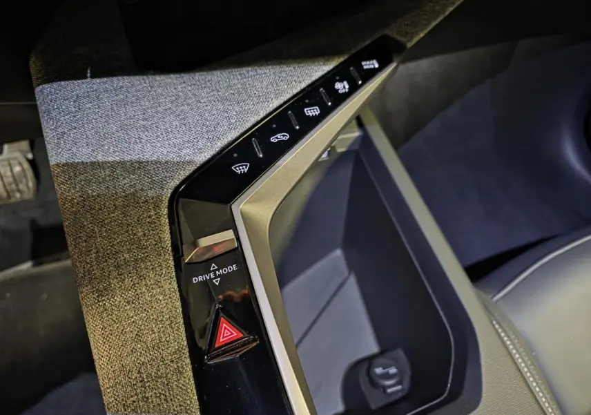 Gros plan sur la console centrale du Peugeot 3008 blanc 2025, avec bouton Drive Mode et tissu gris chiné.