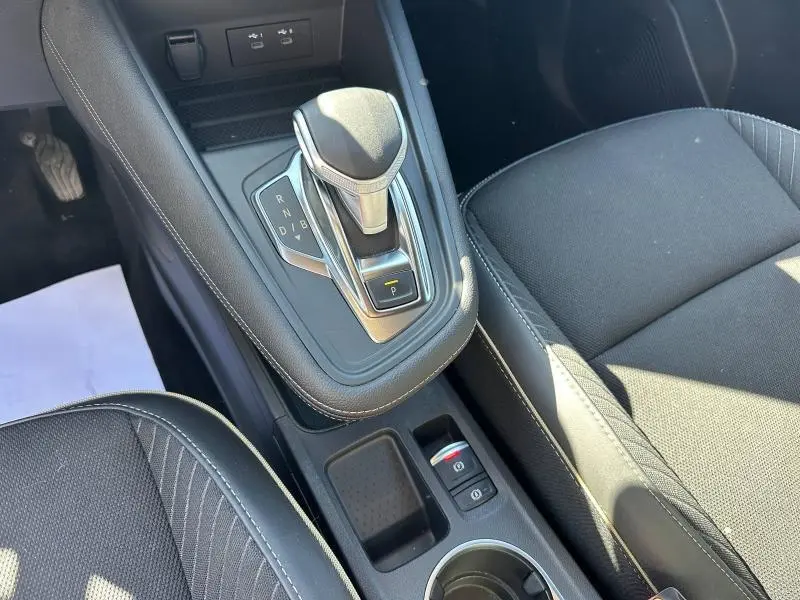 Vue rapprochée de la console centrale noire avec levier de vitesse automatique et siège tissu côté droit du Renault Symbioz 2025.