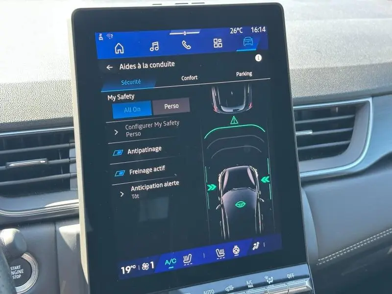 Écran tactile central montrant les aides à la conduite dans l’habitacle d’une Renault Symbioz rouge, tableau de bord visible.