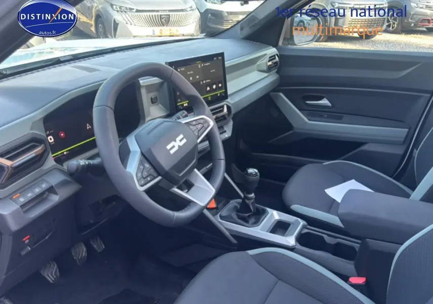 Vue intérieure côté conducteur du Dacia Bigster blanc 2026, volant multifonction et écran tactile central visibles.