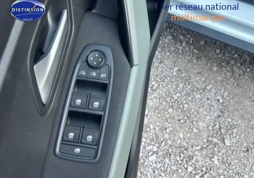 Gros plan sur la commande des vitres électriques côté conducteur d'une Dacia Bigster blanche, porte ouverte.