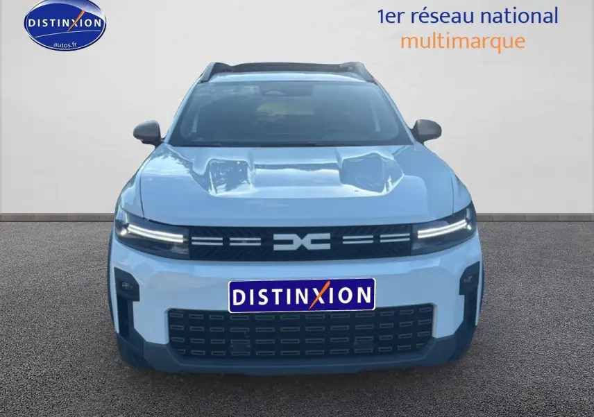 Vue frontale d'un Dacia Bigster blanc 2026 avec calandre noire et phares LED fins allumés.