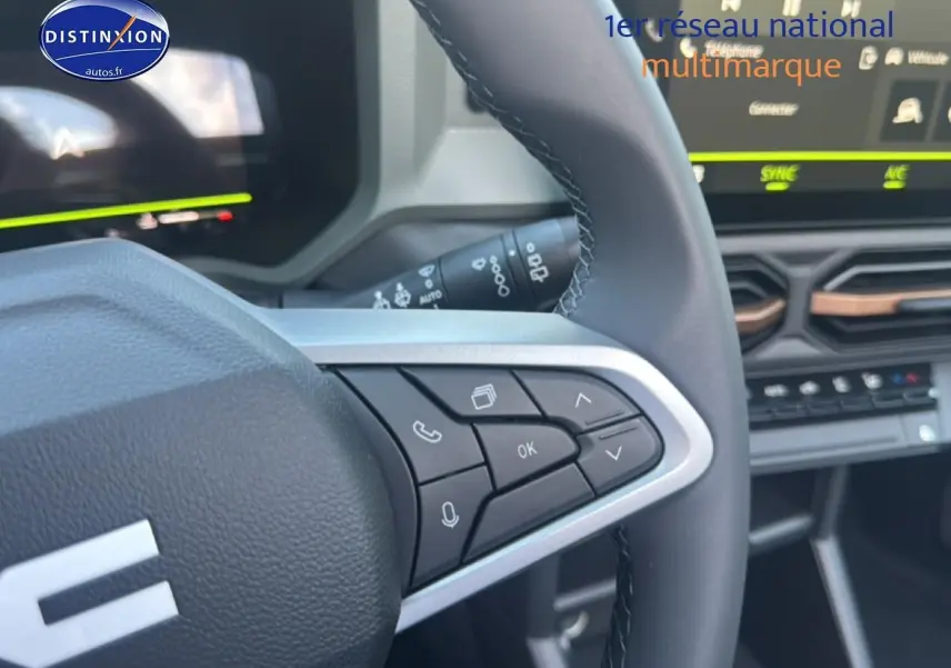 Gros plan sur le volant multifonction noir avec commandes intégrées du tableau de bord du Dacia Bigster blanc.