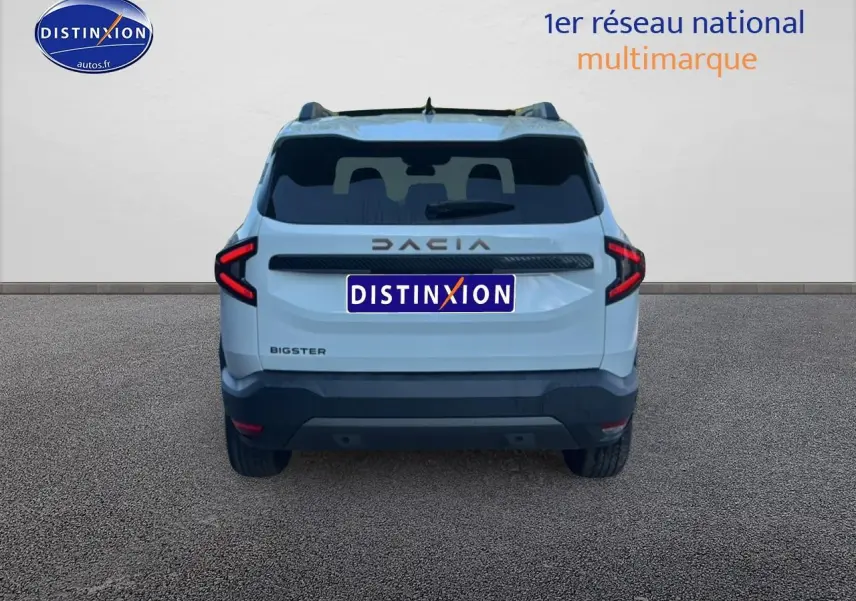 Vue arrière du Dacia Bigster blanc 2026 avec feux arrière LED en forme de flèche et toit noir.