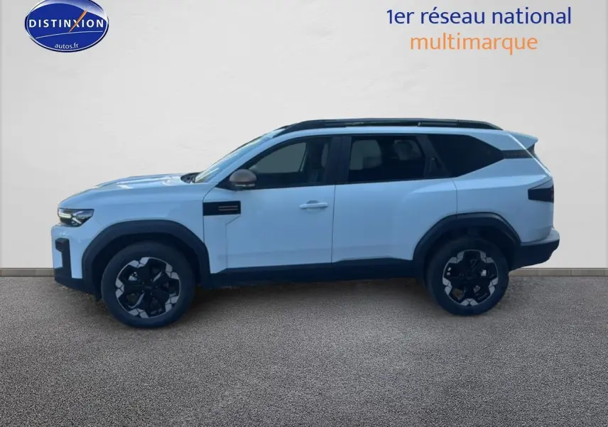 Profil droit du Dacia Bigster blanc 2026 avec jantes noires et barres de toit visibles.