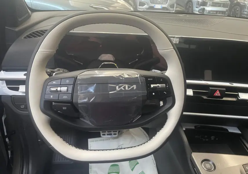Volant blanc et noir du Kia Sportage hybride 2026 vu de face, avec commandes intégrées et tableau de bord moderne.
