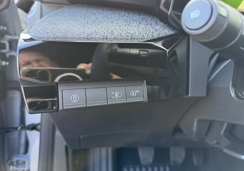 Détail des commandes sous le tableau de bord côté gauche de la Renault Clio VI TCE 115 Techno gris Rafale.