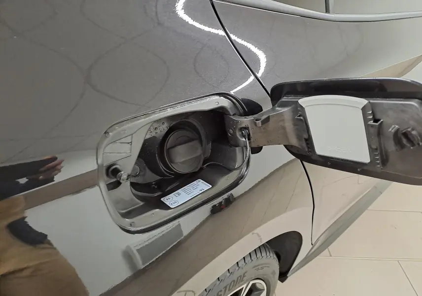 Gros plan sur la trappe à carburant ouverte côté gauche de la Skoda Fabia 2024 noire Magic Nacré.