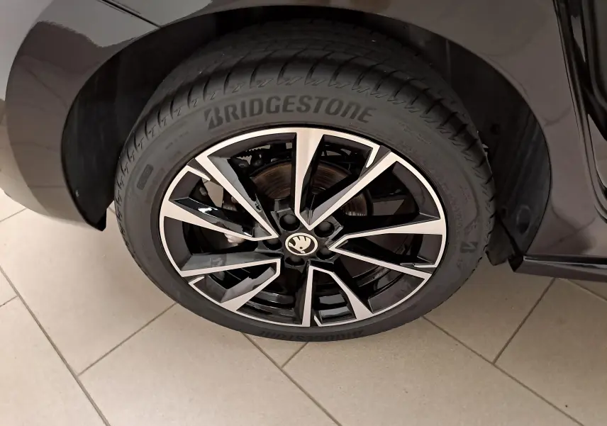 Gros plan sur la roue avant gauche de la Skoda Fabia 1.5 TSI 150 DSG7 Monte-Carlo en Noir Magic Nacré avec jante alliage bicolore.