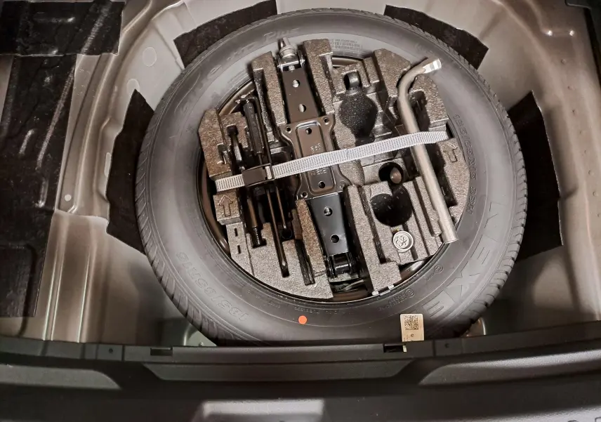 Roue de secours avec outils de bord rangés dans le coffre d'une Skoda Fabia 1.5 TSI 150 DSG7 Monte-Carlo 2024.