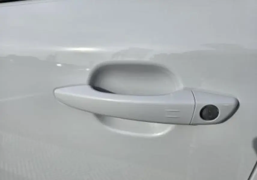 Poignée de porte blanche côté gauche du Peugeot 2008 hybride 2025 avec capteur d'ouverture intégré.