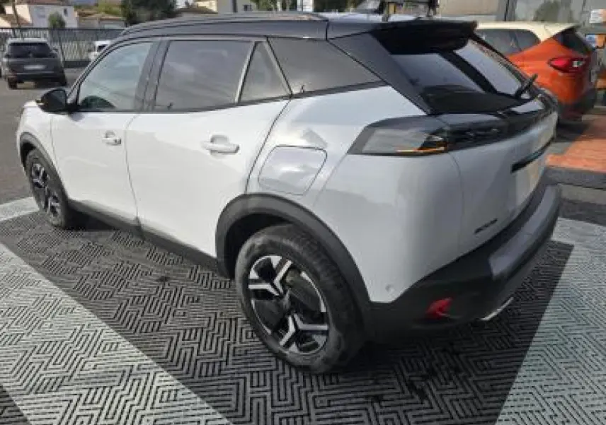 Vue 3/4 arrière droite du Peugeot 2008 blanc Okenite avec toit noir et jantes alliage bi-ton 17 pouces.