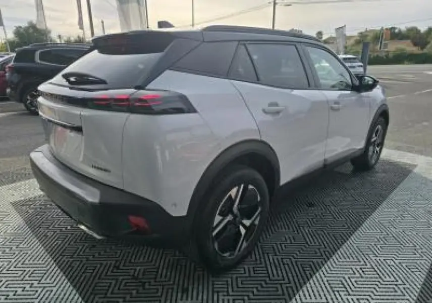 Vue 3/4 arrière droite du Peugeot 2008 blanc Okenite avec toit noir et jantes alliage bi-ton 17 pouces.