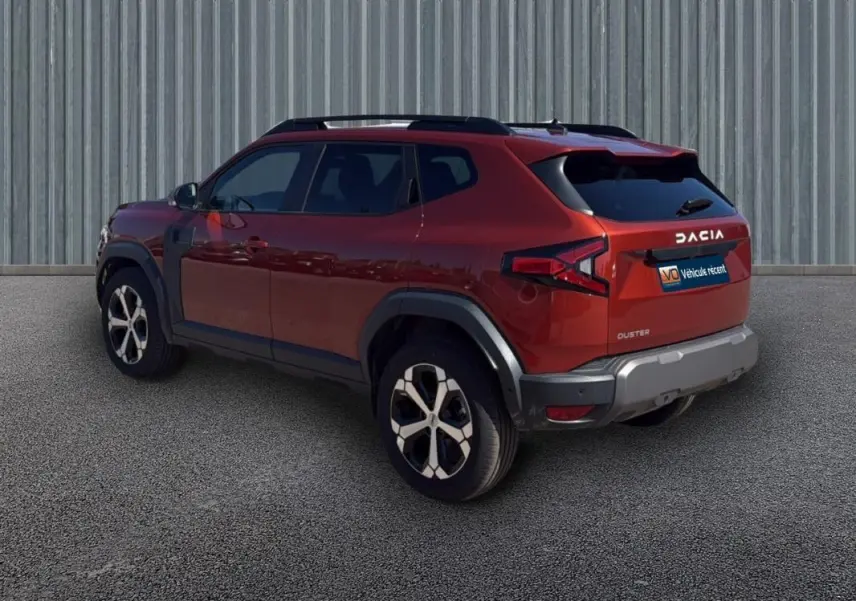 Vue 3/4 arrière droite d'un Dacia Duster orange 2025 avec jantes alliage 18 pouces et vitres surteintées.