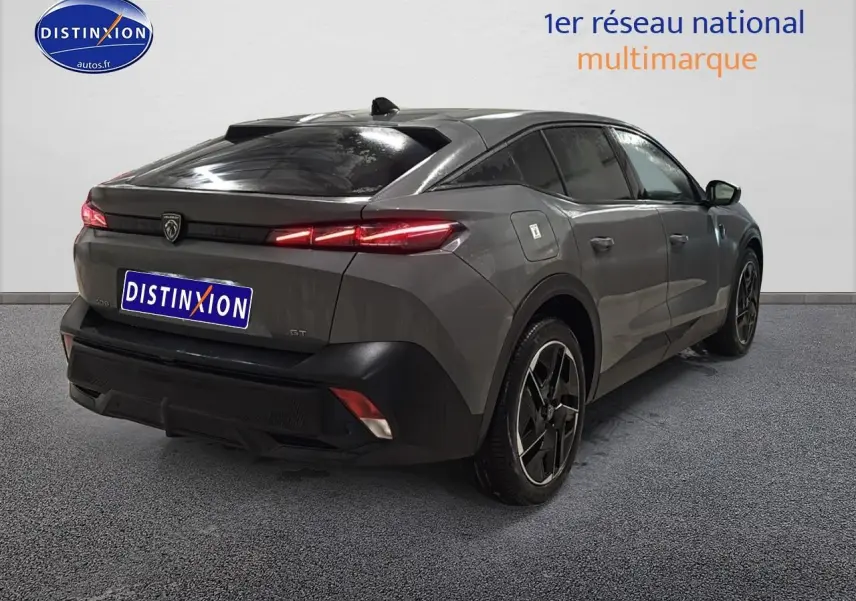 Vue 3/4 arrière droite d'une Peugeot 408 Hybrid 145 GT gris sélénite avec feux arrière LED allumés et jantes alu noires.