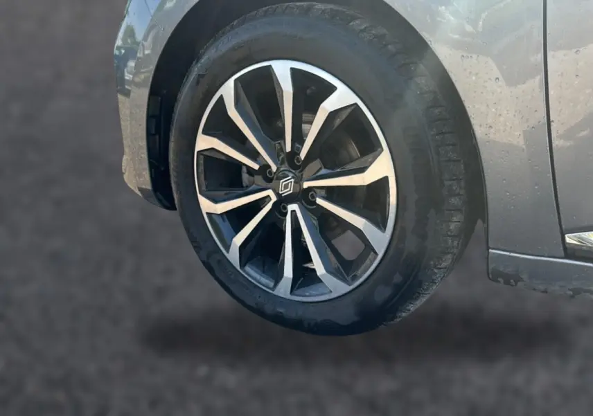 Gros plan sur la roue avant droite de la Renault Clio V gris schiste, mettant en valeur la jante alu au design moderne.