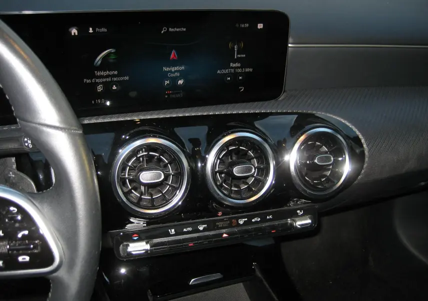 Vue rapprochée de la console centrale de la Mercedes Classe A 180d 2021, avec écran tactile et aérateurs ronds chromés.