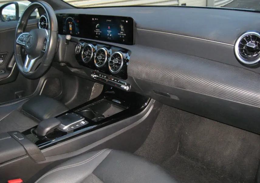 Intérieur de la Mercedes Classe A 180d Business Line 2021, vue de profil gauche sur le tableau de bord et la console centrale noire.