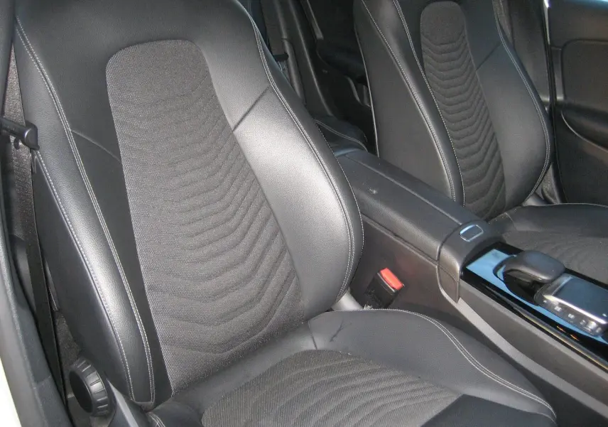 Vue rapprochée des sièges avant en cuir noir et tissu gris d’une Mercedes Classe A 180d Business Line 2021.