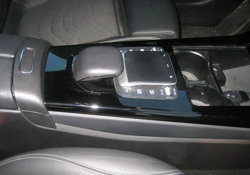 Vue rapprochée de la console centrale noire brillante avec levier de vitesse et commandes tactiles du Mercedes Classe A gris 2021.