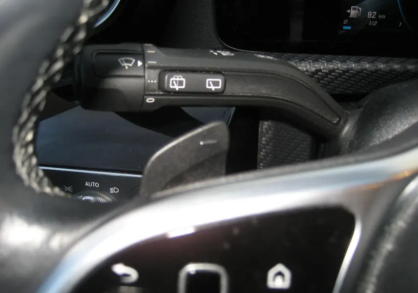 Gros plan sur la commande d’essuie-glace et palette de changement de vitesse du volant noir d’une Mercedes Classe A gris 2021.