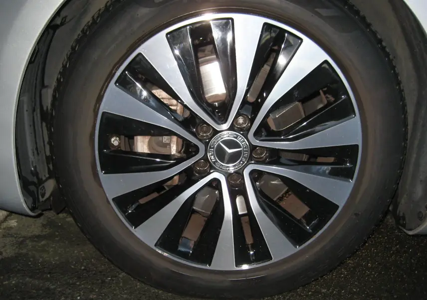 Gros plan sur la jante bi-ton noire et argent d'une Mercedes Classe A180D gris 2021, avec logo étoile central.
